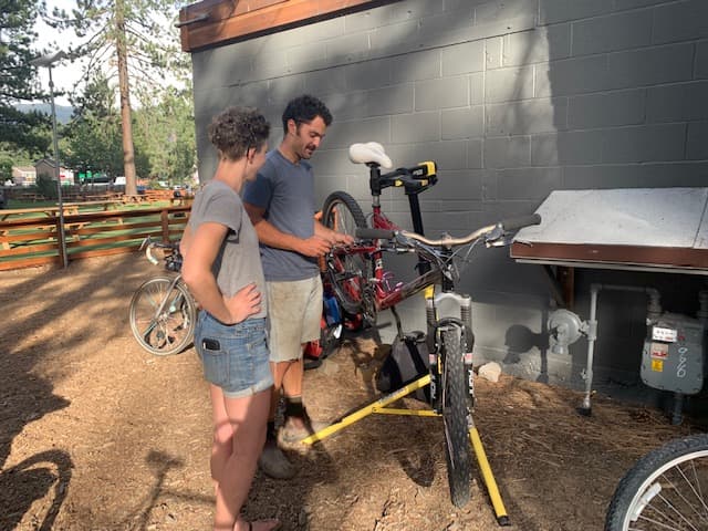 Two volunteers adjusting a bike clamped in a repair stand